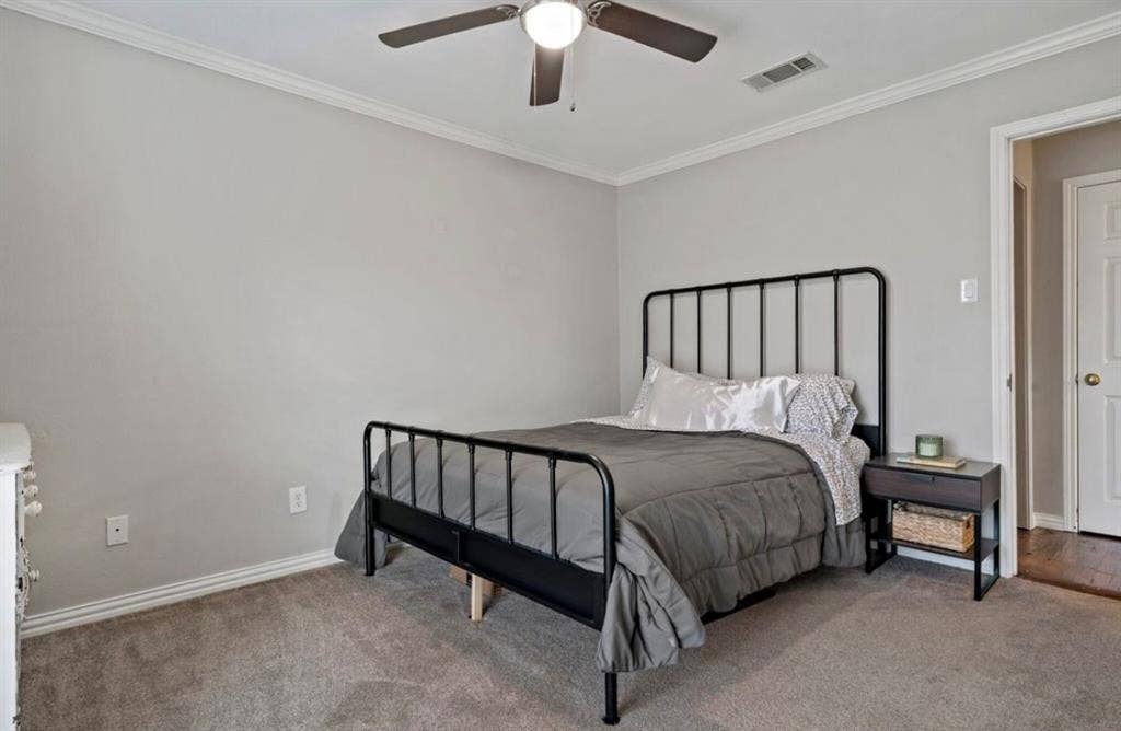 1603 Vicksburg Drive, Sachse, TX 75048 Bedroom with ornamental molding, visible vents, and carpet flooring