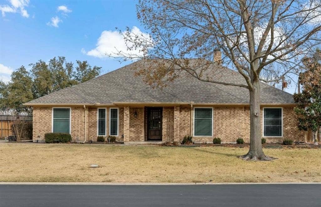 1603 Vicksburg Drive, Sachse, TX 75048 Ranch-style house with brick siding, a shingled roof, fence, and a front yard