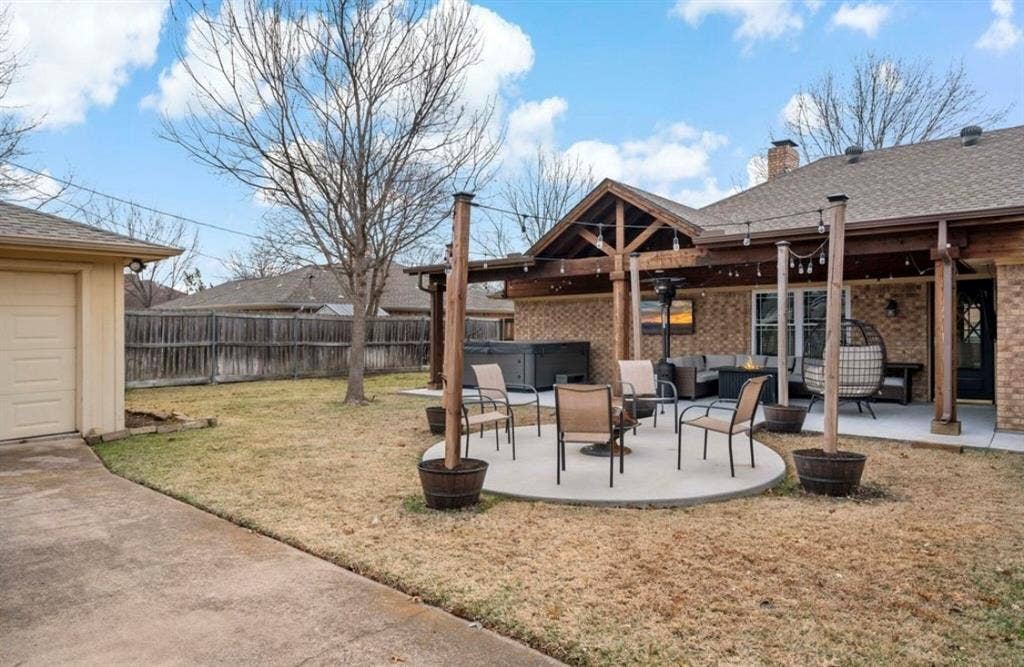 1603 Vicksburg Drive, Sachse, TX 75048 View of yard with a hot tub, outdoor lounge area, a fenced backyard, and a patio