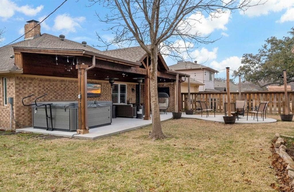 1603 Vicksburg Drive, Sachse, TX 75048 Back of house with brick siding, a patio, a lawn, a hot tub, and an outdoor fire pit