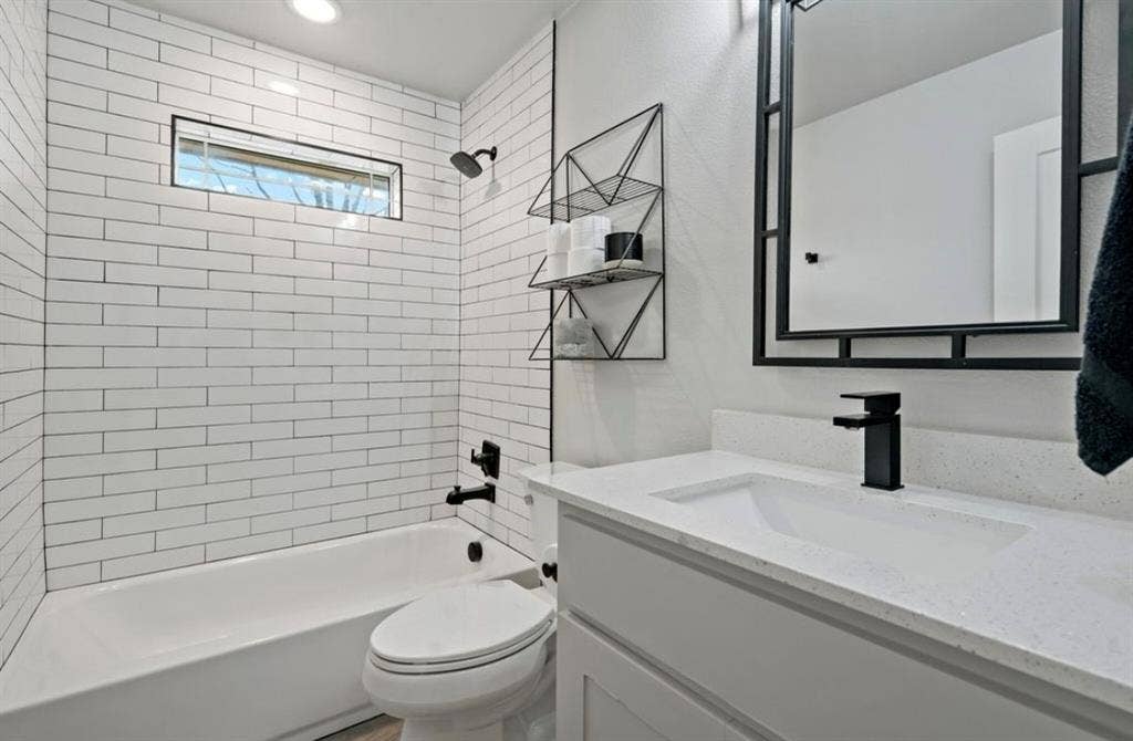 1603 Vicksburg Drive, Sachse, TX 75048 Bathroom with washtub / shower combination, vanity, and toilet