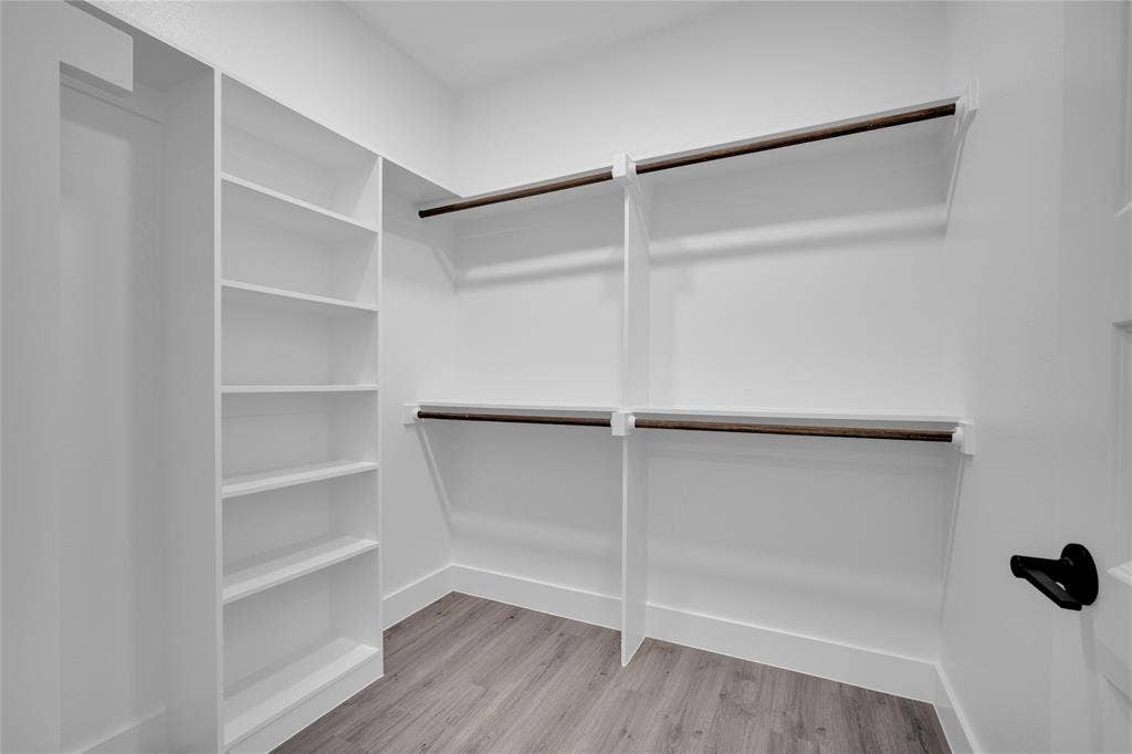 1995 Lakeview Drive, Kemp, TX 75143 Built-in shelving, multiple hanging rods, and wood-finish flooring