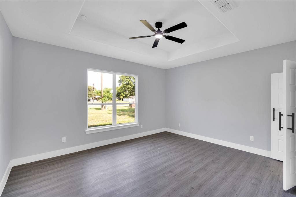 1995 Lakeview Drive, Kemp, TX 75143 Tray ceiling with a ceiling fan, wood-finish flooring, white trim, and a window providing natural illumination