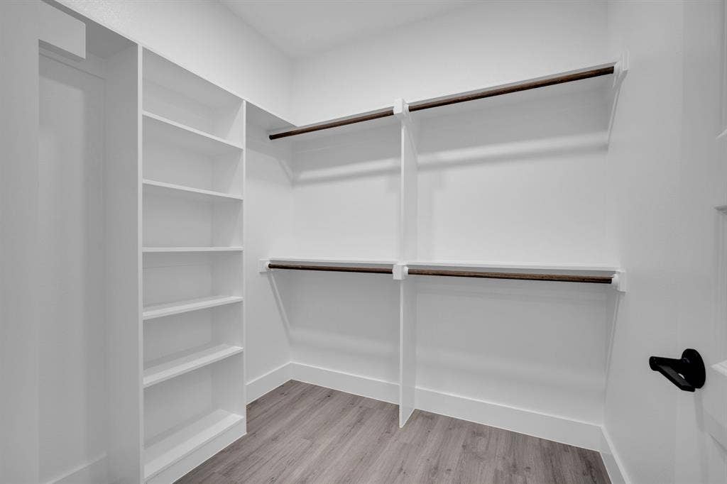 1995 Lakeview Drive, Kemp, TX 75143 Built-in shelving, dual hanging rods, white finishes, and wood-finish flooring