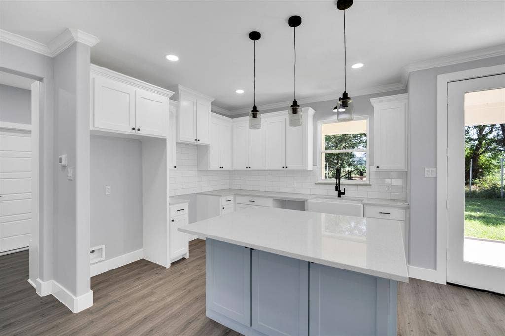 1995 Lakeview Drive, Kemp, TX 75143 Kitchen featuring white shaker cabinetry, an island with a light-colored countertop, wood-finish flooring, and pendant lighting