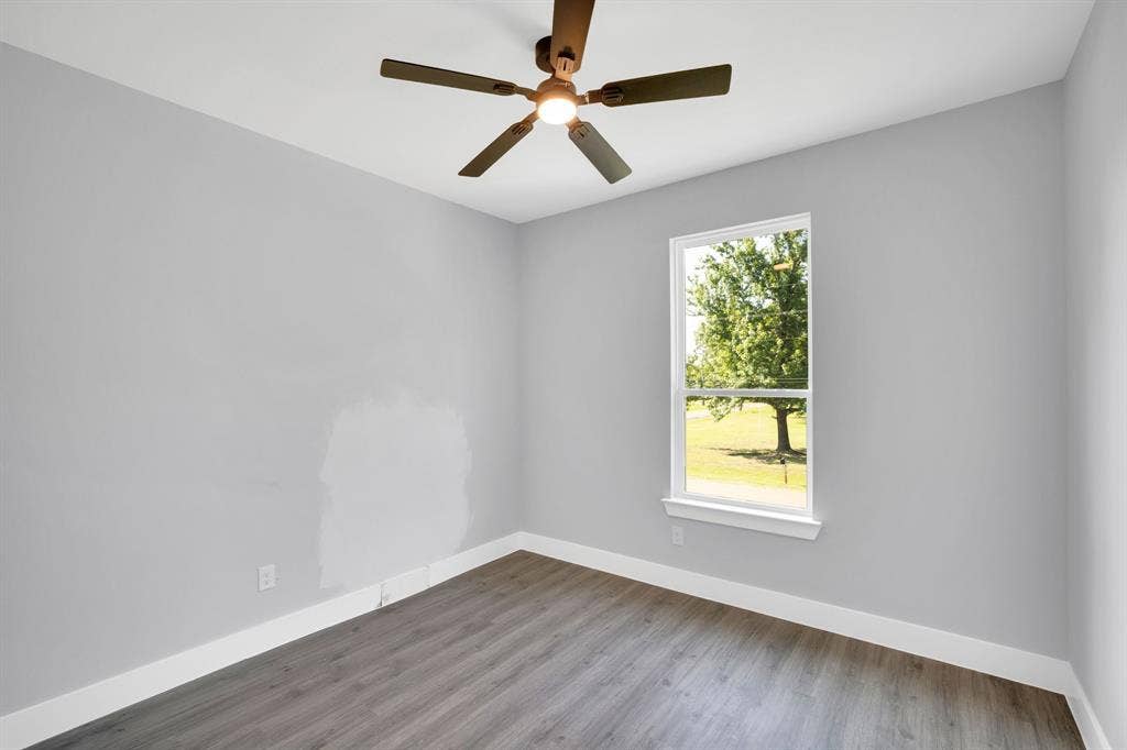 1995 Lakeview Drive, Kemp, TX 75143 Wood-finish flooring with white trim, a single window, and a ceiling fan with integrated lighting