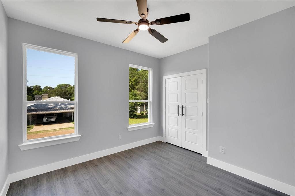 1995 Lakeview Drive, Kemp, TX 75143 Wood-finish flooring, two large windows, white trim, a ceiling fan with light, and paneled double doors