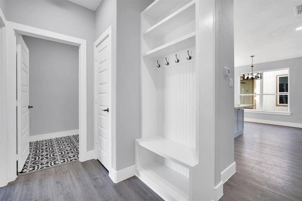 1995 Lakeview Drive, Kemp, TX 75143 Built-in mudroom bench with shelving and coat hooks, wood-finish flooring, and white trim throughout