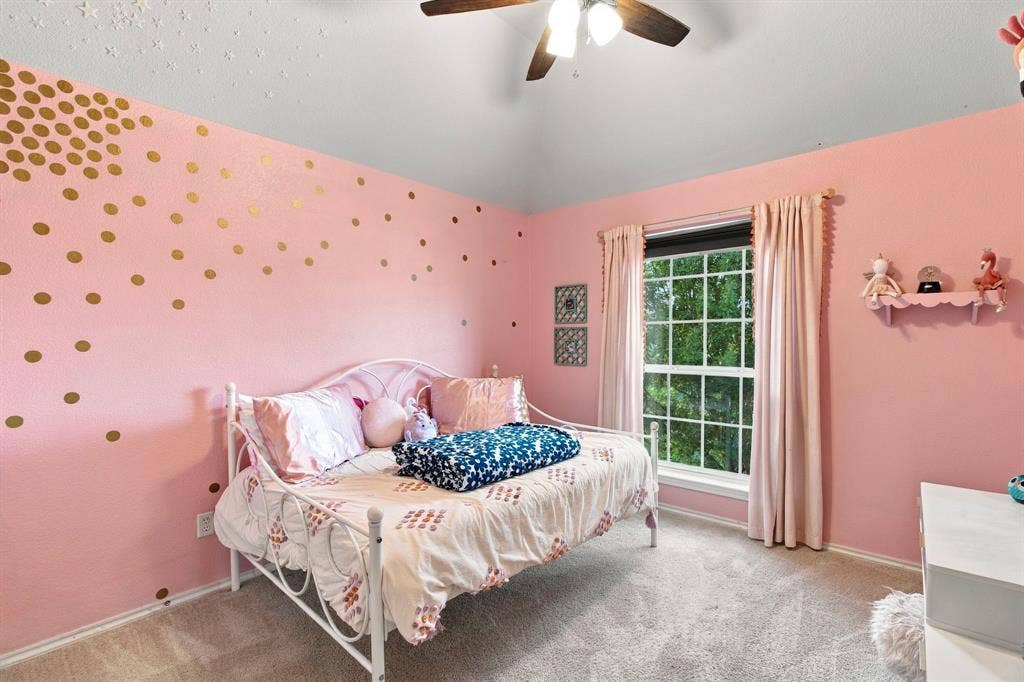 Bedroom featuring a high vaulted ceiling, neutral wall-to-wall carpeting, and a multi-blade ceiling fan with integrated light fixture