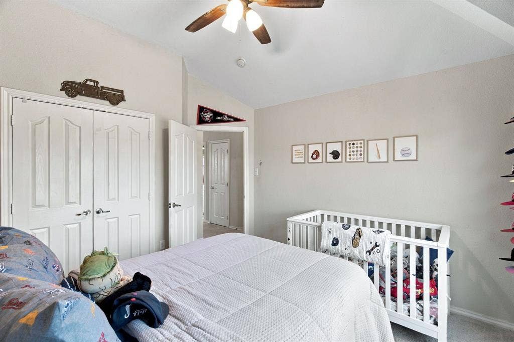 Vaulted ceiling featuring a central ceiling fan with integrated lighting, paired with double-panel closet doors