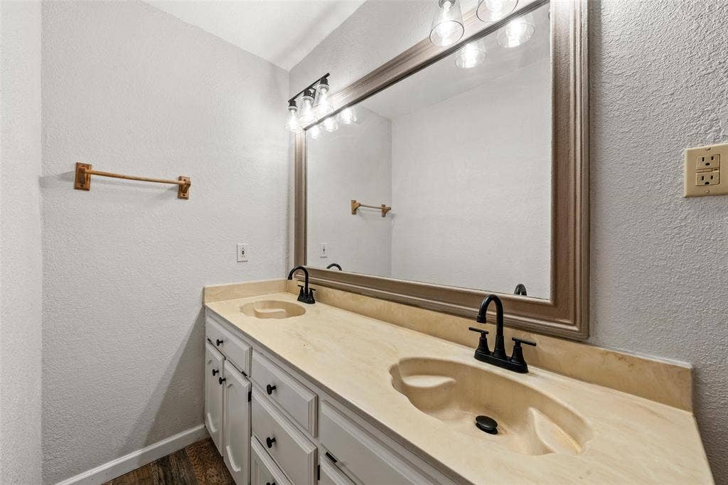 812 Regina Drive, Hewitt, TX 76643 Double vanity with integrated sinks, matte black faucets, white cabinetry, and wood-finish flooring