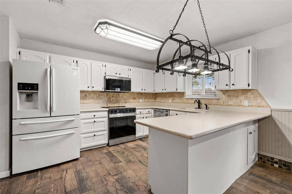 812 Regina Drive, Hewitt, TX 76643 Kitchen featuring white cabinetry, wood-finish flooring, an island with countertop, stainless steel appliances, and a decorative pot rack fixture