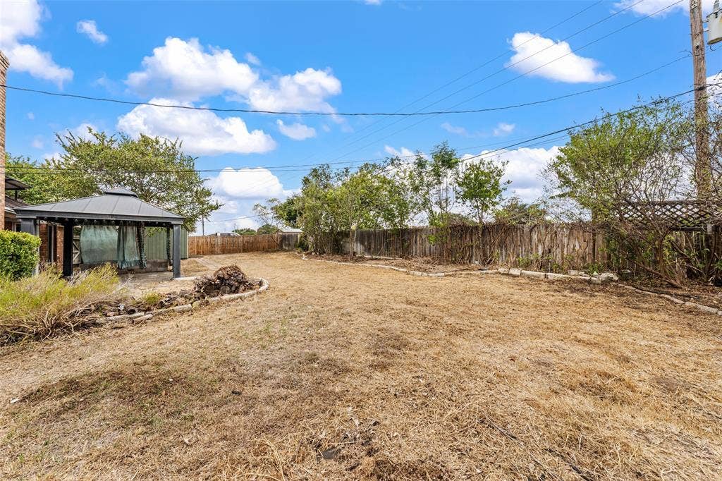 812 Regina Drive, Hewitt, TX 76643 Spacious backyard featuring a gazebo, fenced perimeter, and mature trees