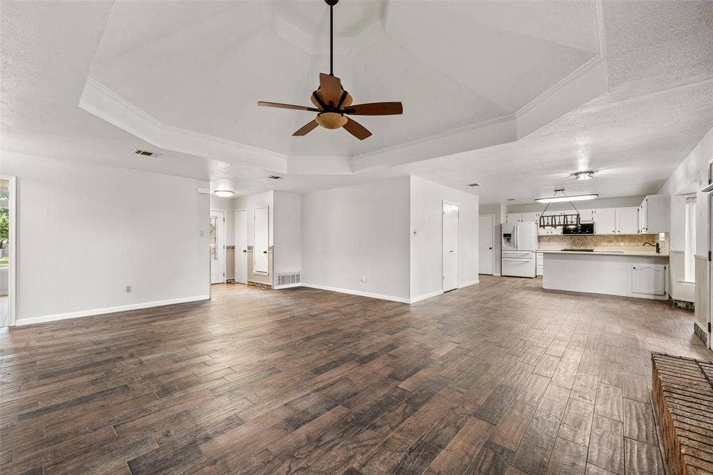 812 Regina Drive, Hewitt, TX 76643 Open-concept living space featuring a tray ceiling, wood-finish flooring, and a ceiling fan