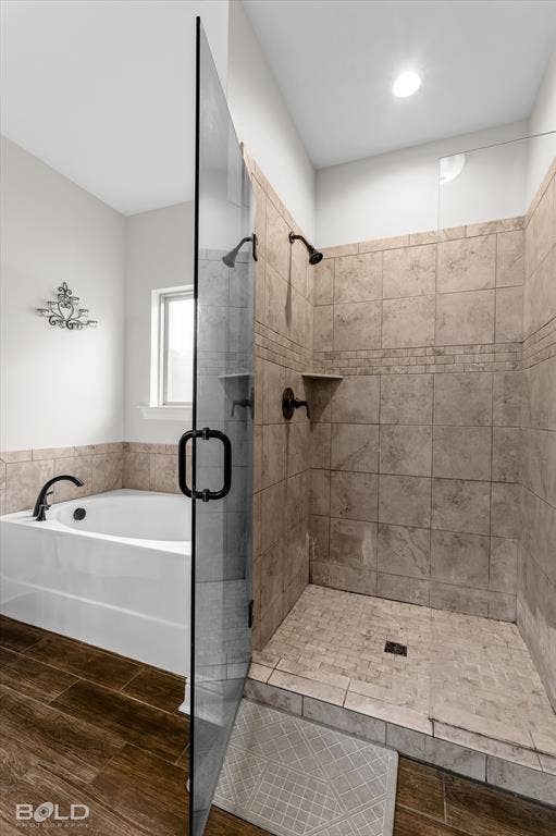 Walk-in shower with tiled walls and floor, featuring a built-in shelf and dark bronze fixtures