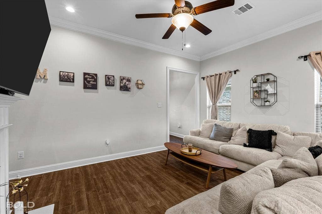 Wood-finish flooring, crown molding, recessed lighting, and a ceiling fan with integrated lighting