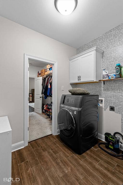 Wood-finish flooring, overhead flush mount light fixture, white cabinetry with dark hardware, built-in shelving, and light-toned wall covering