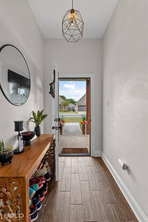 Geometric pendant light fixture, wood-finish flooring, white trim, and a white interior door