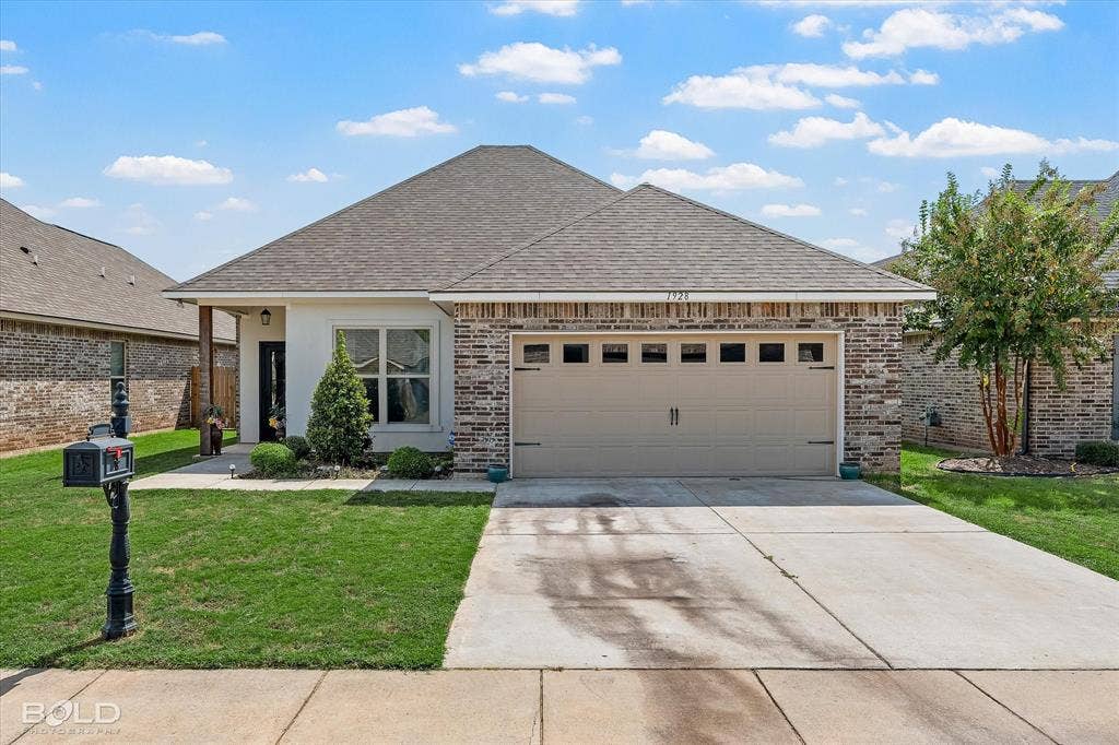 Exterior featuring a brick and siding facade, a gabled roof, an attached garage, a concrete driveway, and a covered entry