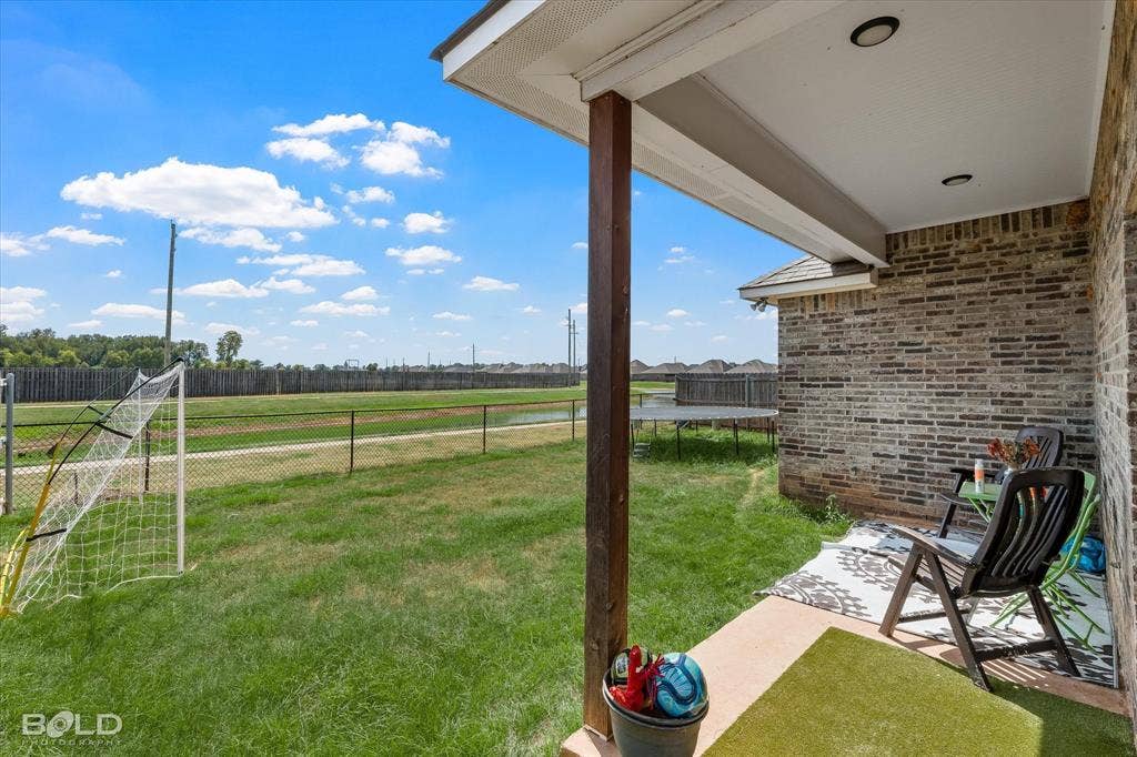 Covered patio with recessed lighting, brick exterior wall, and wood column
