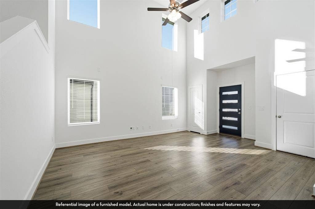 5218 Noland Drive, Princeton, TX 75071 Vaulted ceilings featuring multi-level windows, wood-finish flooring, and a contemporary entry door with horizontal glass inserts
