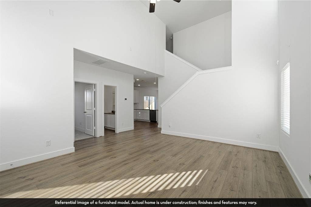 5218 Noland Drive, Princeton, TX 75071 High-ceiling interior featuring wood-finish flooring, a neutral color palette, and a staircase with a built-in railing