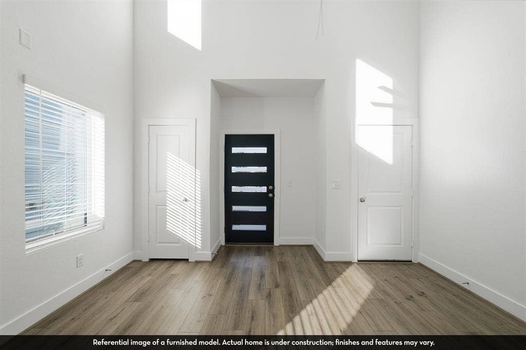 821 Whitmore Drive, Princeton, TX 75071 High-ceiling interior featuring wood-finish flooring, a multi-paneled front entry door, and large-scale windows with fitted blinds