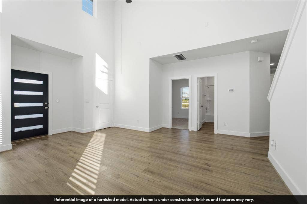 821 Whitmore Drive, Princeton, TX 75071 Double-height ceiling, wood-finish flooring, and modern entry door with horizontal frosted glass inserts
