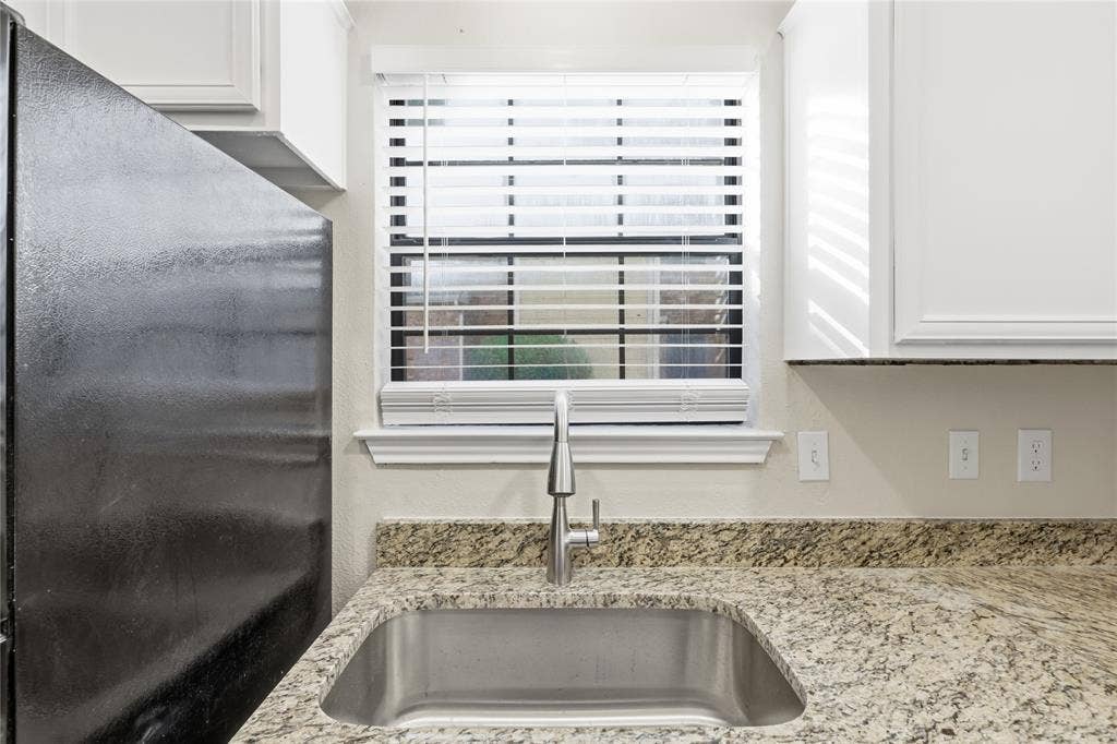 4414 Point Boulevard, #115, Garland, TX 75043 Stainless steel sink with a gooseneck faucet, light-toned granite countertops, and white upper cabinetry