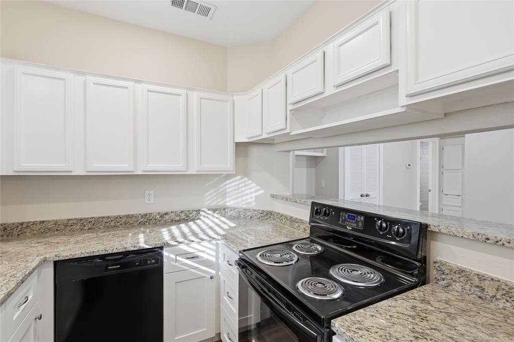 4414 Point Boulevard, #115, Garland, TX 75043 Kitchen featuring white cabinetry, granite countertops, black electric range, and black dishwasher