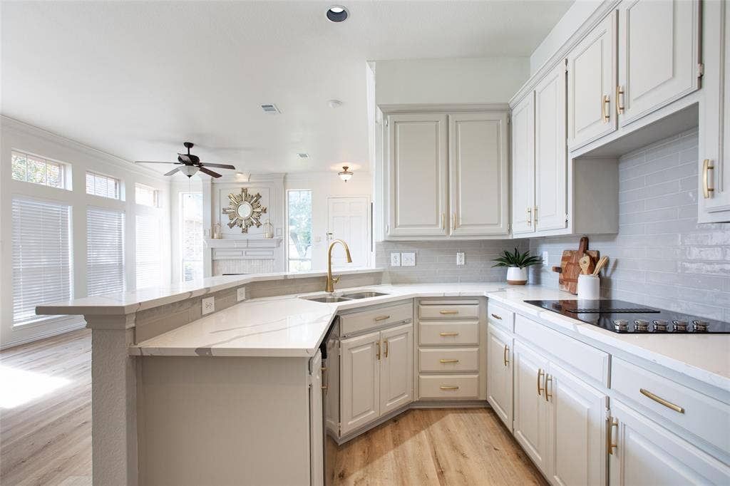 Freshly painted kitchen cabinets, timeless backsplash, and new gold hardware.