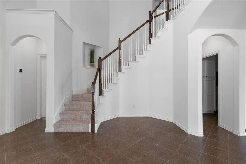 Grand staircase with wood-finish handrail and brand new carpeted