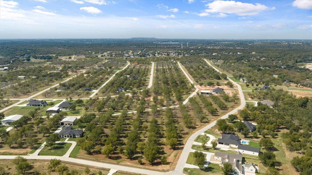 2013 Skylane Drive, Granbury, TX 76049 Aerial perspective of a rural subdivision featuring paved street infrastructure and established native tree groves