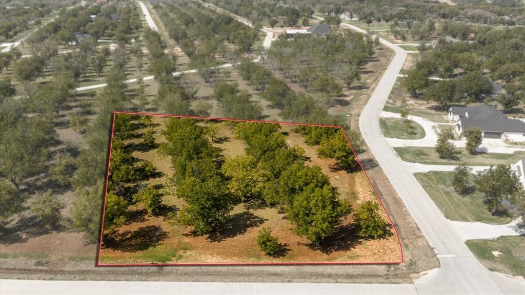 2013 Skylane Drive, Granbury, TX 76049 Corner lot featuring mature trees, paved street access, and established landscaping