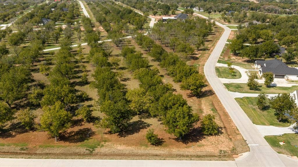 2013 Skylane Drive, Granbury, TX 76049 Aerial perspective of expansive acreage featuring mature trees, established paved roadways, and cleared terrain