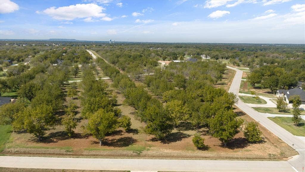 2013 Skylane Drive, Granbury, TX 76049 Expansive corner lot featuring mature trees, paved street access, and cleared terrain