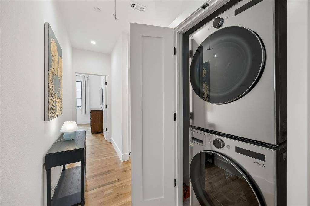 7207 Gaston Avenue, #903, Dallas, TX 75214 Laundry Room: This area features a stacked washer and dryer, light oak wood-finished floors, and is conveniently located between the two bedrooms.