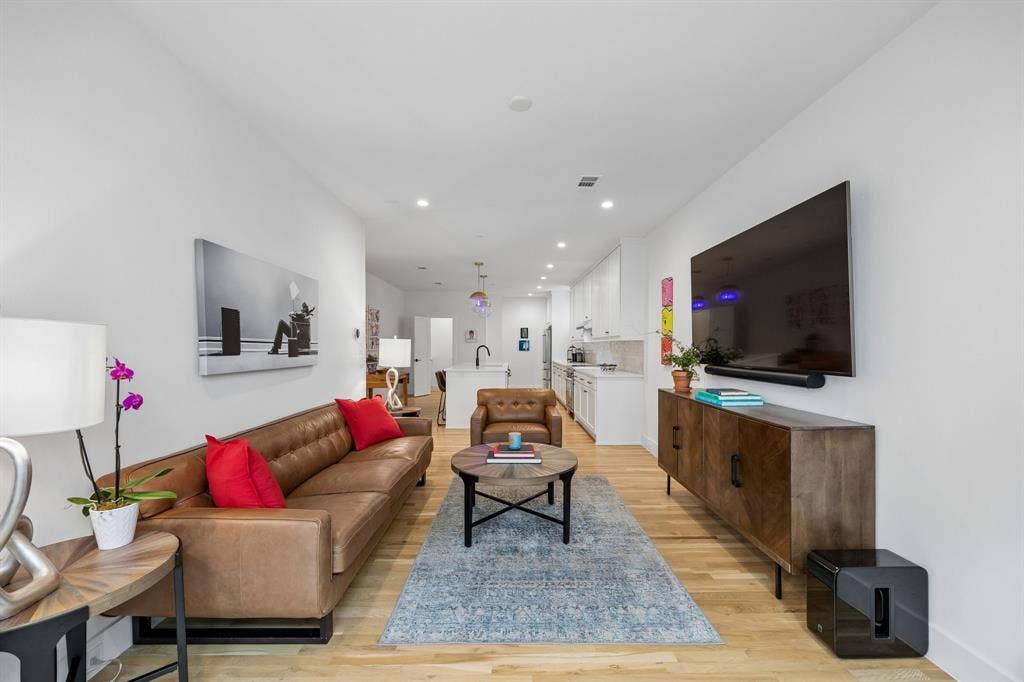 7207 Gaston Avenue, #903, Dallas, TX 75214 Bright and inviting living area looking back into the open kitchen space. This description highlights the key features of the photo, emphasizing the open concept and the welcoming atmosphere of the space. It paints a picture of a comfortable and functional living area seamlessly connected to the kitchen.......