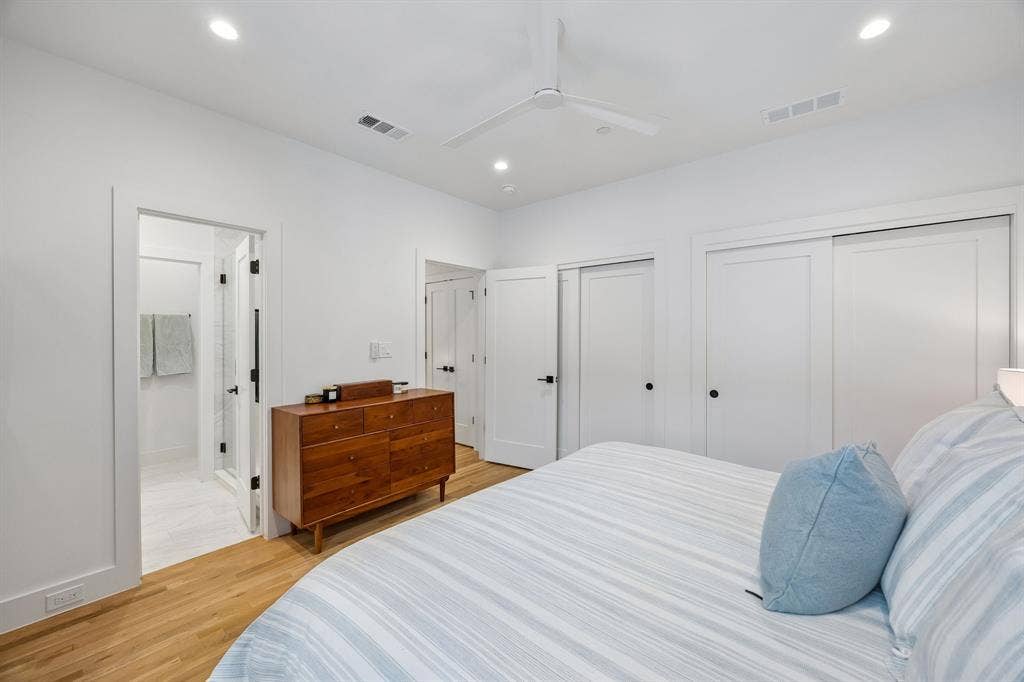 7207 Gaston Avenue, #903, Dallas, TX 75214 Bedroom with light oak wood floors, two closets, a ceiling fan, and recessed lighting with en-suite bathroom, dual sinks and walk-in shower