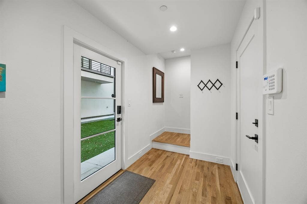 7207 Gaston Avenue, #903, Dallas, TX 75214 Front entry landing with light oak wood-finished flooring and recessed lighting, offering a convenient drop zone for personal items.