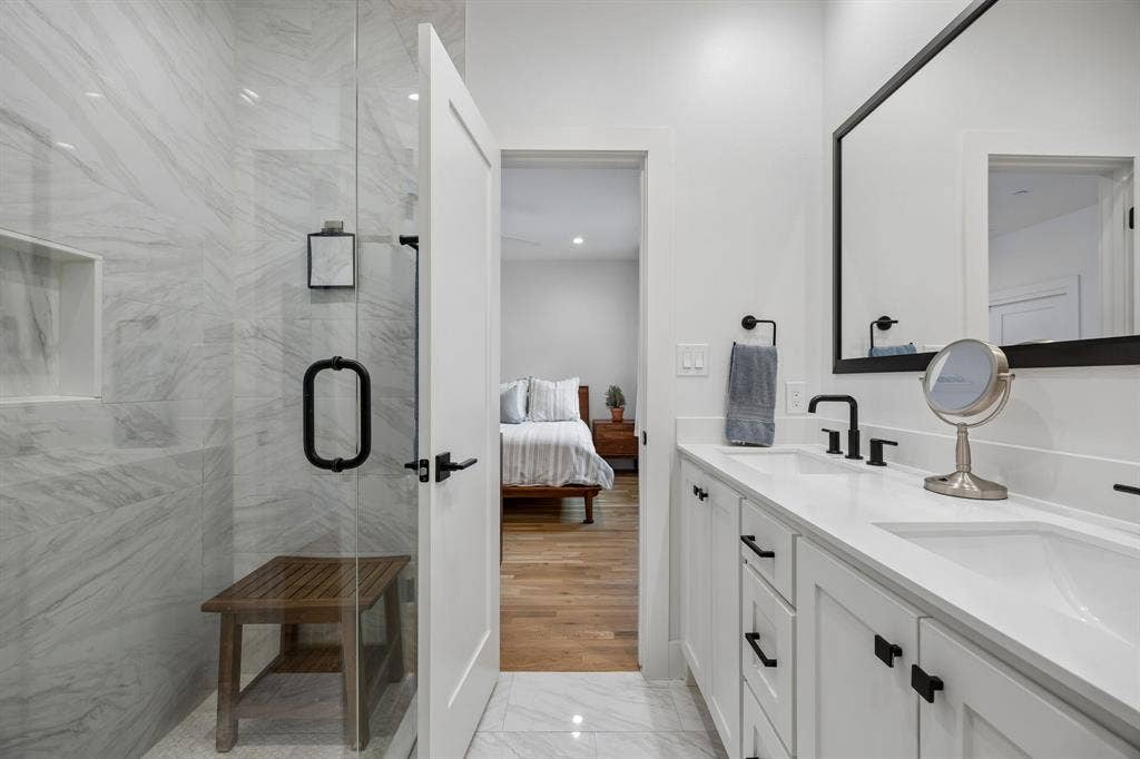 7207 Gaston Avenue, #903, Dallas, TX 75214 Bathroom with double vanity, ensuite bathroom, a marble finish shower, and light marble finish floors
