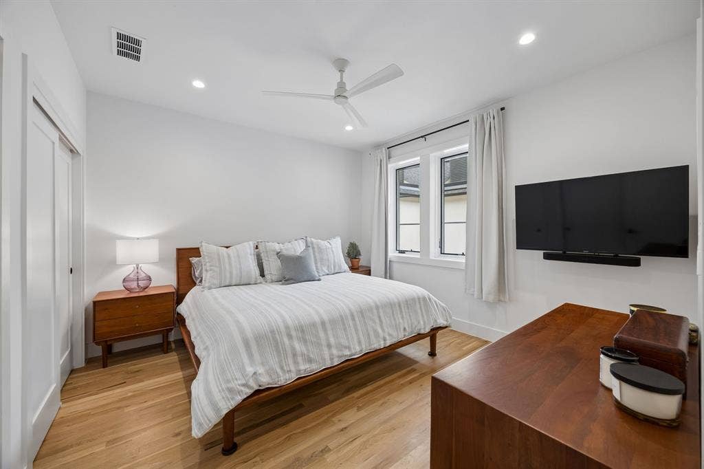 7207 Gaston Avenue, #903, Dallas, TX 75214 Bedroom featuring light oak wood flooring, recessed lighting, a ceiling fan, and a dual closet system.