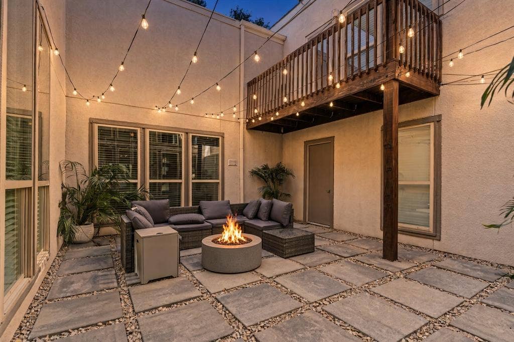 6423 Ridgemont Drive, Dallas, TX 75214 Night View of Private Courtyard featuring large format pavers, and exterior string lighting