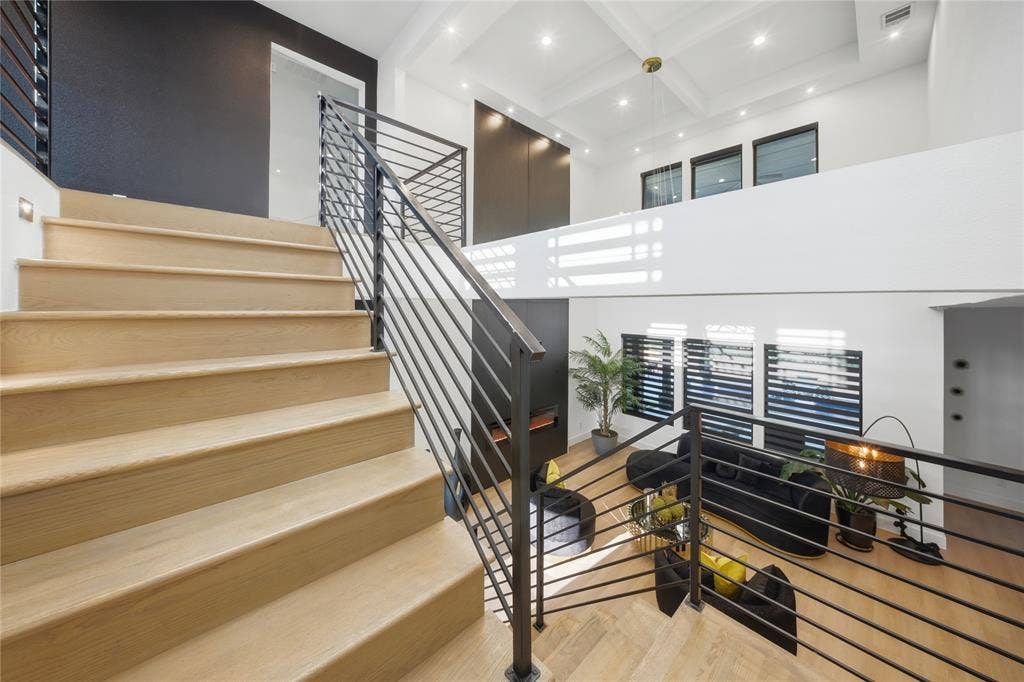 522 S Clark Road, Cedar Hill, TX 75104 Open-concept living space featuring wood-finish flooring, a modern staircase with metal railings, high ceilings with recessed lighting, and multiple windows with horizontal blinds