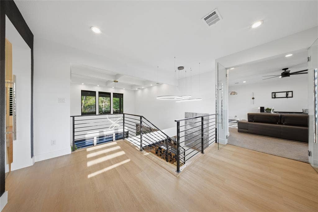 522 S Clark Road, Cedar Hill, TX 75104 Wood-finish flooring, contemporary staircase with horizontal metal balusters, modern chandelier, recessed lighting, and glass panel entry door