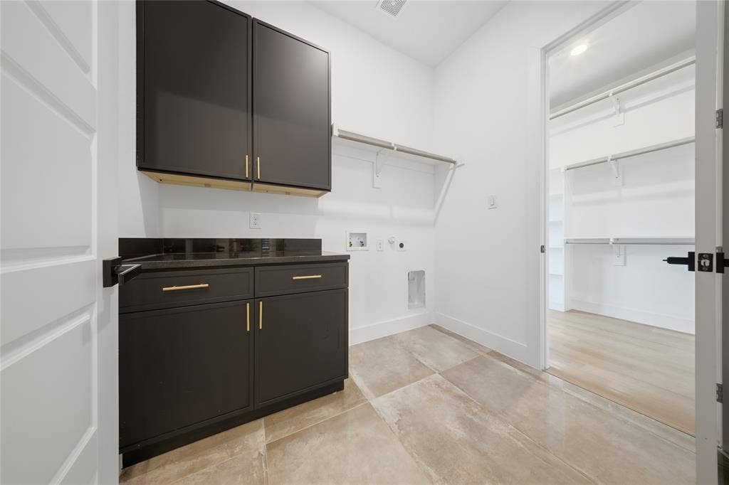 522 S Clark Road, Cedar Hill, TX 75104 Built-in dark cabinetry with gold-tone hardware, dark countertop, and tiled flooring