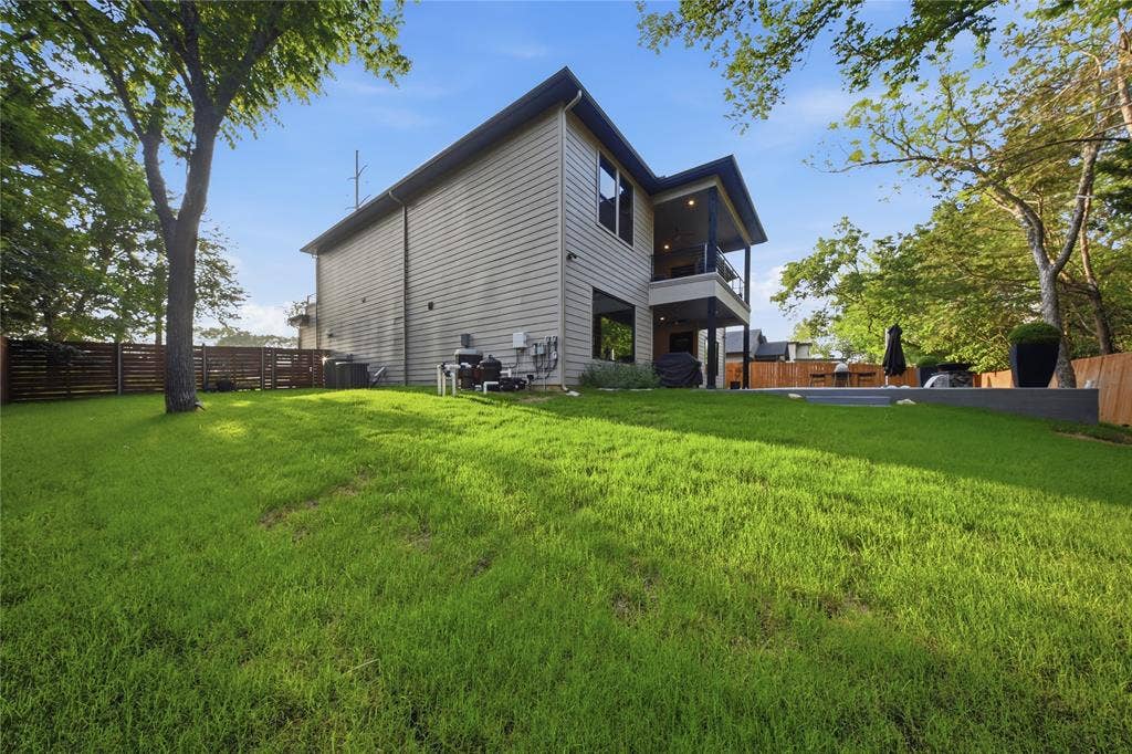 522 S Clark Road, Cedar Hill, TX 75104 Expansive backyard featuring a large lawn, a private patio, a second-story balcony, and a horizontal slat fence