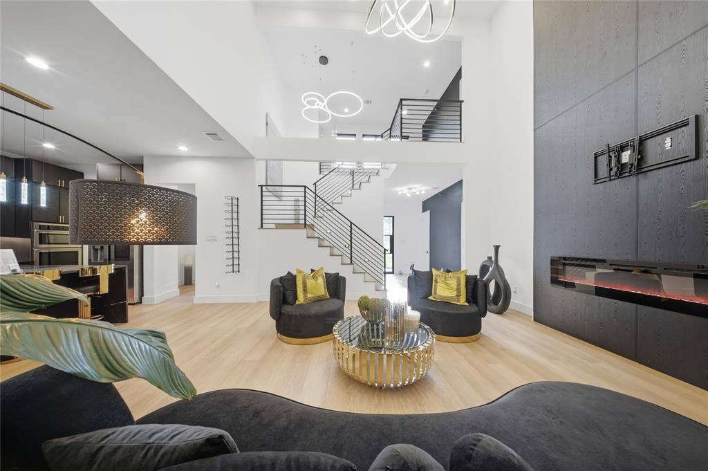 522 S Clark Road, Cedar Hill, TX 75104 High ceilings, wood-finish flooring, two-story staircase with horizontal metal railings, modern linear fireplace, and contemporary lighting fixtures