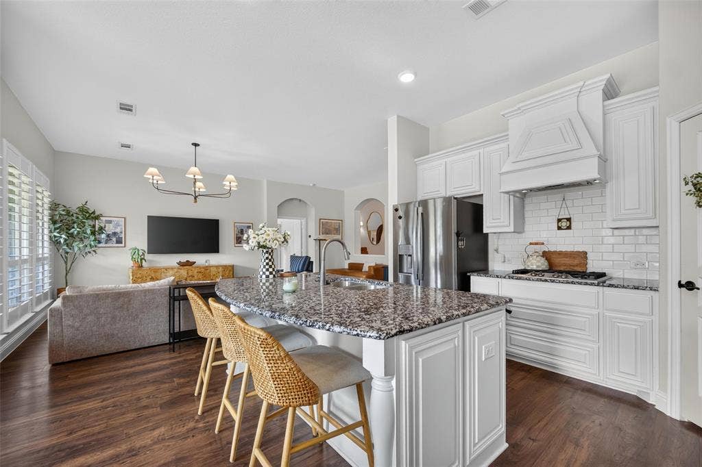 3210 Creekhaven Drive, Melissa, TX 75454 Kitchen featuring white cabinetry, a central island with a multi-tonal countertop, a subway tile backsplash, and wood-finish flooring