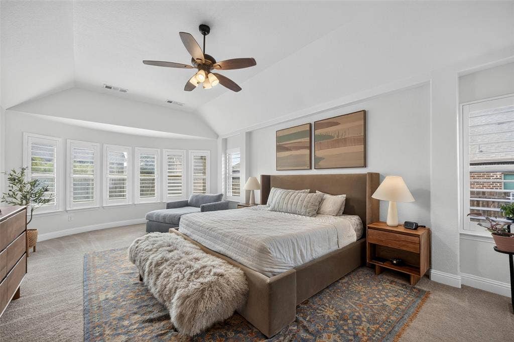 3210 Creekhaven Drive, Melissa, TX 75454 Vaulted ceiling with a central multi-blade ceiling fan, expansive bay window featuring plantation shutters, and neutral carpeting